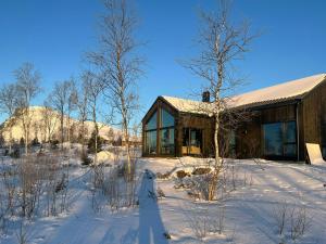 eine Blockhütte im Schnee mit schneebedeckten Bäumen in der Unterkunft Mountain Cabin With Beautiful Lake View in Markegardlian