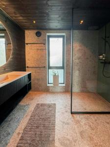 ein Badezimmer mit Glasdusche und Waschbecken in der Unterkunft Mountain Cabin With Beautiful Lake View in Markegardlian