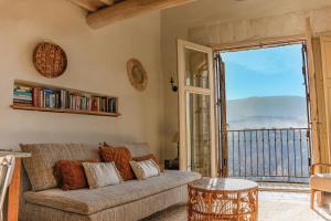 メネルブにあるHilltop House With Luberon Views In Ménerbesのソファとバルコニーのあるリビングルーム