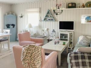sala de estar con sillas rosas y TV en Cabin At Fagerstrand With Oslofjord Views, en Spro