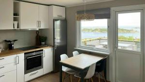 LangenesにあるBeautiful Cabin With Ocean View In Lyngmyrの水辺の景色を望むキッチン(テーブル付)