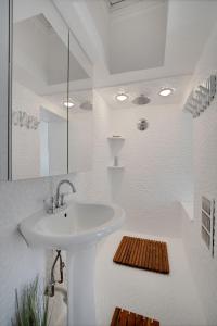 un bagno bianco con lavandino e specchio di Incredible 2BR Rittenhouse Row a Philadelphia Altre 20 foto