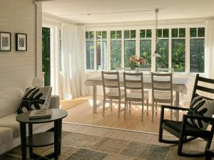 un salon avec une table et des chaises de salle à manger dans l'établissement Traditional Cottage Near Linné's Råshult, à Stenbrohult 12 autres photos
