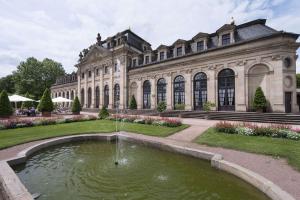 un gran edificio con un estanque frente a él en Maritim Hotel Am Schlossgarten en Fulda