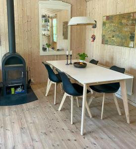 einen Tisch und Stühle in einem Zimmer mit Herd in der Unterkunft Holiday Home By Viking Grave And Protected Nature in Korsør