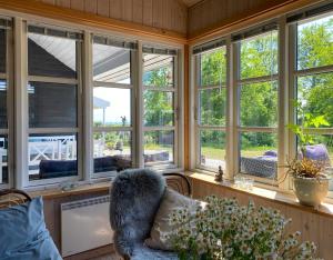 ein Zimmer mit einer Fensterreihe und einer Couch in der Unterkunft Holiday Home By Viking Grave And Protected Nature in Korsør + 10 Fotos