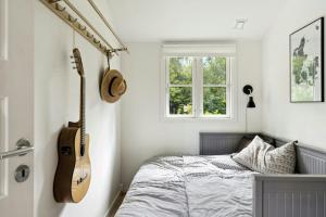 MunkerupにあるThe Small Oasis With Beach Vibes In Dronningmølleのベッドルーム(ギター付)