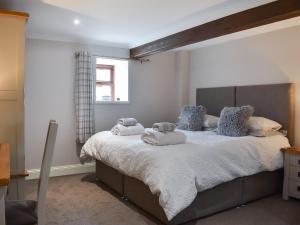 a bedroom with a large bed with towels on it at The Martins - Uk47429 in Bewaldeth