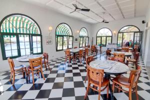 a restaurant with tables and chairs on a checkered floor at Hotel Bahia in Cala Santandria