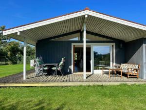 a patio with a table and chairs on a deck at Colourful Holiday Home Near Middelfart Beach in Voldby