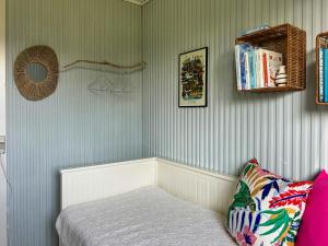 a small room with a bed and a book shelf at Colourful Holiday Home Near Middelfart Beach in Voldby