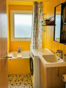 a bathroom with a tub and a sink and a window at Colourful Holiday Home Near Middelfart Beach in Voldby +32 photos