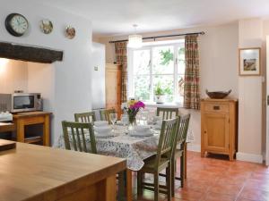 ein Esszimmer mit Tisch und Stühlen in der Unterkunft Wood Cottage in Cheriton