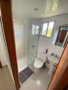 a bathroom with a toilet and a shower and a sink at Beautiful apartment near STGO airport in Santiago de los Caballeros