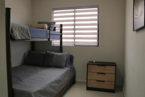 ein Schlafzimmer mit Etagenbetten, einer Kommode und einem Fenster in der Unterkunft Mi Casita San Miguel in San Miguel