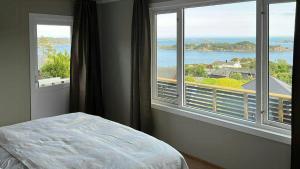LangenesにあるBeautiful Cabin With Ocean View In Lyngmyrの海が見える大きな窓のある寝室