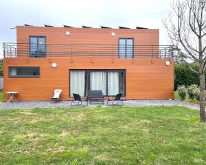 a house with a table and chairs in front of it at Le D-Day - Sauna - A moins de 2 km de la plage in Sainte-Honorine-des-Pertes