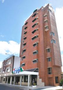 een hoog rood bakstenen gebouw met een hotel bij Hotel Yaguaron in San Nicolás de los Arroyos