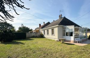 a small white house with a bench in the yard at Chez Micheline et Gilbert in Villebernier