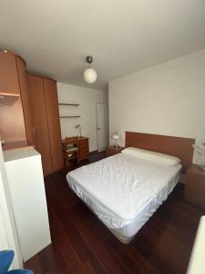 Un dormitorio con una cama blanca en una habitación. en La pallota, en Camino