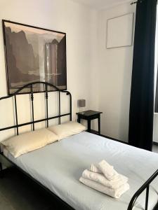a bedroom with a bed with two towels on it at Porta Susa Rooms in Turin