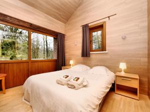a bedroom with a bed with two towels on it at Durbuy Forest Villa with Pool in Grandhan