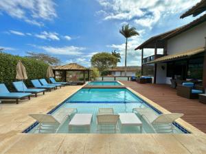 a swimming pool with chaise lounge chairs and a resort at Pousada Ferradura Boutique in Búzios