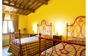 Un dormitorio con una cama y una pared amarilla. en Siena Private Pool Villa, en Belforte