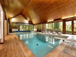 a swimming pool in a house with a large ceiling at Durbuy Forest Villa with Pool in Grandhan
