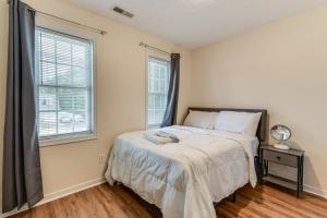 a bedroom with a bed and two windows at Classic Colonial Home with Private Yard in Richmond! in Beulah Village