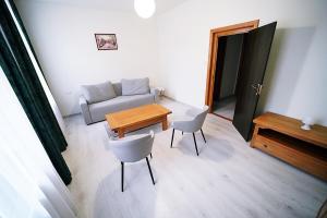a living room with a couch and a table and chairs at Pensiunea Central in Reghin