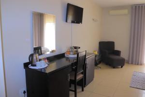 a living room with a kitchen with a table and chairs at Oasis Hotel in Mokopane