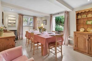 a kitchen and dining room with a table and chairs at Church Cottage in Burford