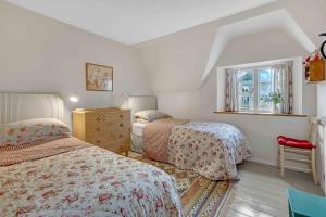 Un dormitorio con dos camas y una ventana. en Church Cottage, en Burford 12 fotos más