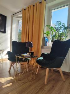 two chairs and a table in a room with a window at Apartament Pułaskiego 11m8 - Centrum Sopotu 1 min do Monciaka in Sopot