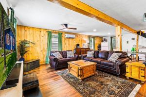 a living room with leather couches and a tv at Lake Livingston Retreat with Firepit, Fishing, and Game Room in Livingston