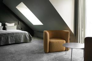 Un dormitorio con una cama, una silla y una mesa. en Hotel Hans, en Copenhague 51 fotos más