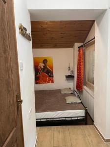 a bedroom with a bed with a painting on the wall at Hacienda Apartman in Békéscsaba
