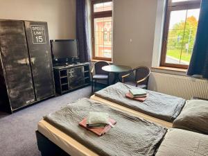 ein Zimmer mit zwei Betten, einem Fernseher und einem Tisch in der Unterkunft Hotel Chicago in Chomutov