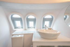 a white bathroom with a sink and three windows at Villa Tholos -Athens Riviera in Kalívia Thorikoú +69 photos