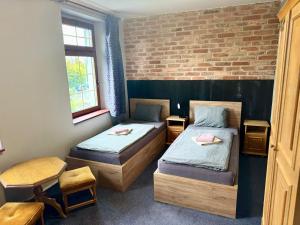 ein Zimmer mit zwei Betten und einer Ziegelwand in der Unterkunft Hotel Chicago in Chomutov