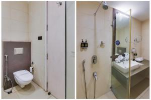 a bathroom with a shower and a toilet and a sink at Bluestone Prime by The Cosy Hotels in New Delhi