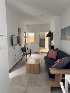 Una sala de estar con un sofá azul y una mesa. en City Beach 1, en Las Palmas de Gran Canaria