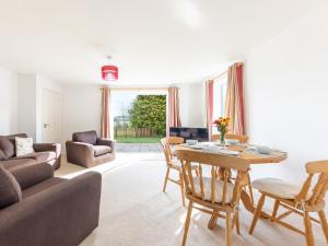 Great RyburghにあるBetty's Houseのソファとテーブルと椅子のあるリビングルーム