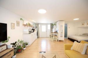 a living room with a couch and a bed and a kitchen at המקום של מוש in Pardes H̱anna