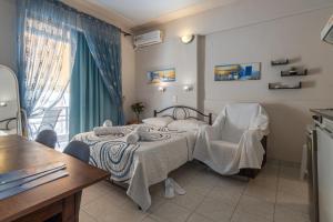 干尼亚阿伦娜公寓的一间卧室，里面有一张床、一把椅子和一扇窗户。