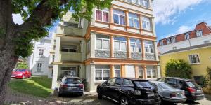 two cars parked in front of a building at Ferienwohnung Charlot mit 2 Schlafzimmern & Bio-Kamin in Heringsdorf