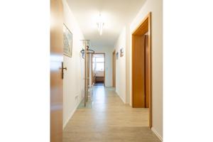 a hallway with white walls and wooden floors at Ferienwohnung Charlot mit 2 Schlafzimmern & Bio-Kamin in Heringsdorf +7 photos