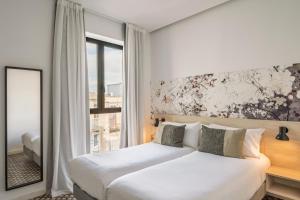 a bedroom with a white bed and a window at Aspasios Poble Nou Apartments in Barcelona +17 photos