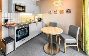 une petite cuisine avec une table et des chaises dans l'établissement Ferienwohnung Trassenheide, à Trassenheide